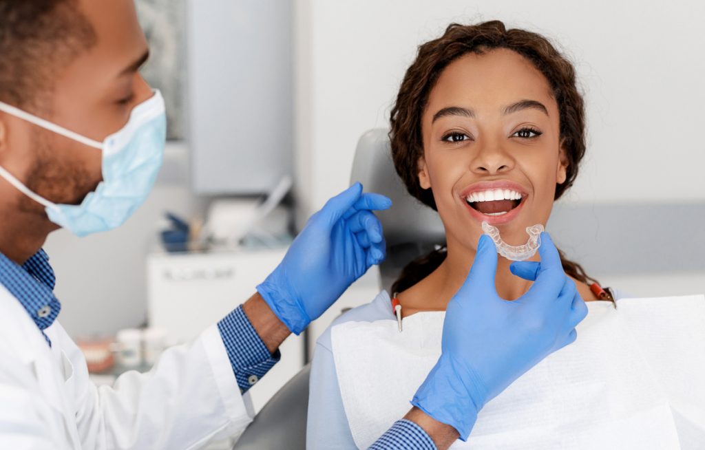 DrSmile Erfahrungen: Junge Frau beim Zahnarzt bekommt Aligner