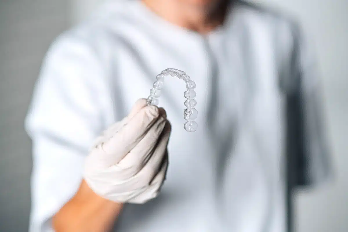 Dentist holds invisible dental splint in hand