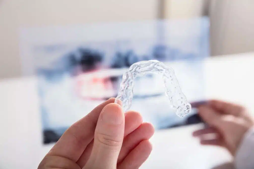 Woman holding aligner in hand - closeup