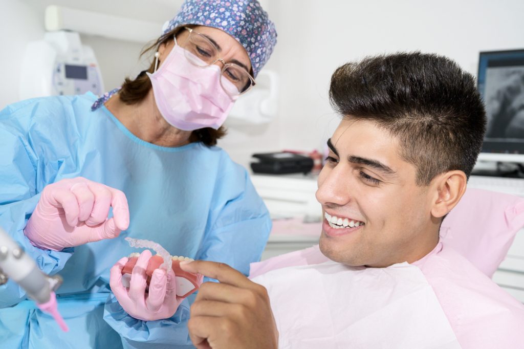 Junger Mann bekommt Aligner beim Zahnarzt