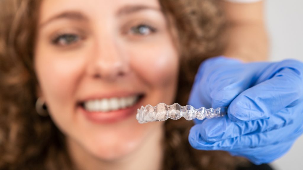 Young woman at the dentist gets her aligners