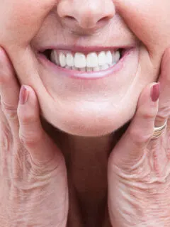 Ältere Frau lächelt in die Kamera - PlusDental Kosten
