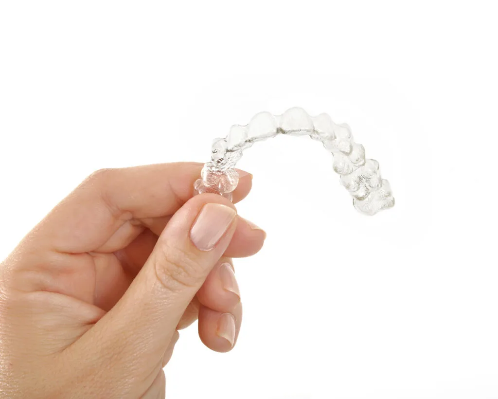 Woman holding aligner in hand