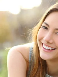 Junge Frau lacht strahlend in die Kamera - DrSmile vs Smileunion