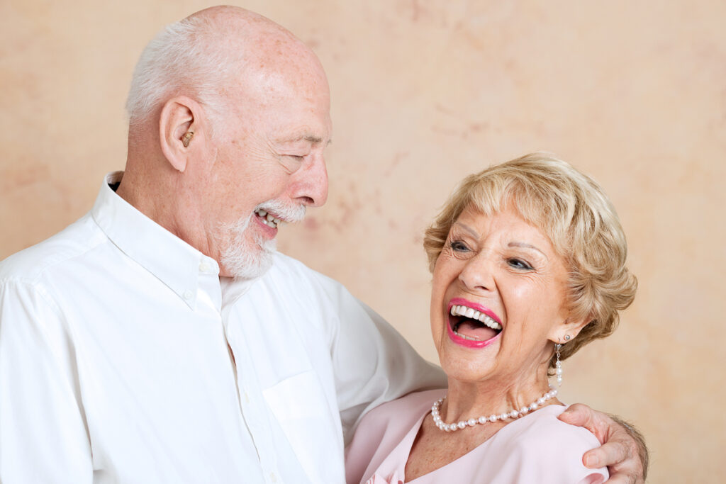 Äldre par skrattar in i kameran