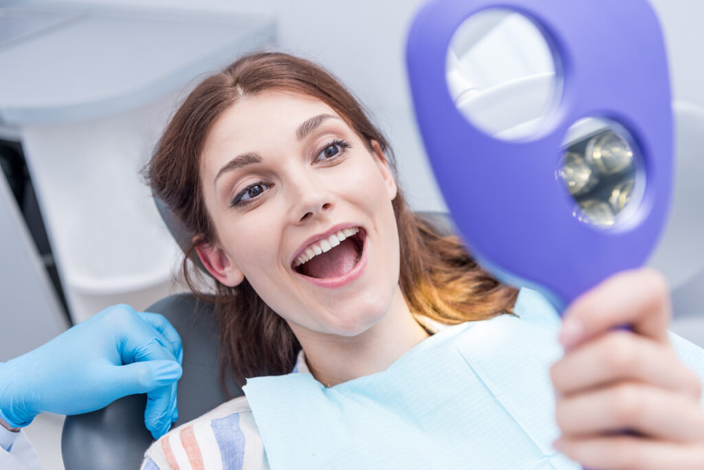 Junge Frau lächelt beim Zahnarzt