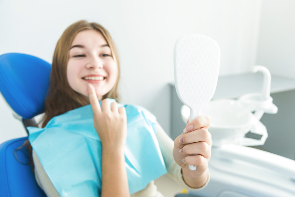 Młoda kobieta uśmiechnięta u dentysty  
