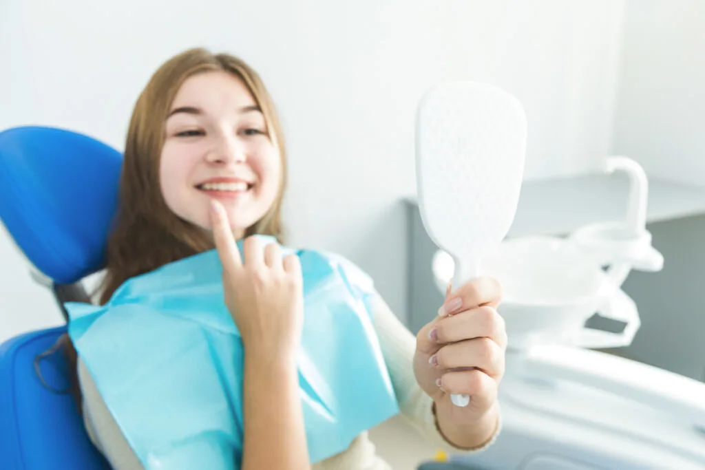 Mujer joven sonriendo al dentista 