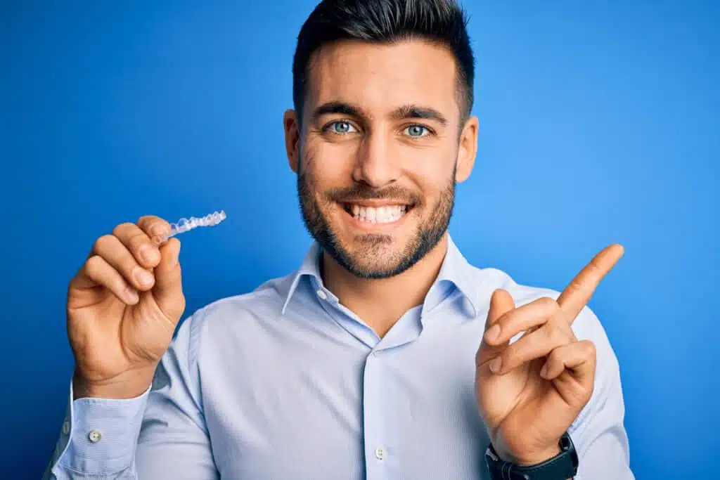 Young man holds LetSmile aligner in his hand